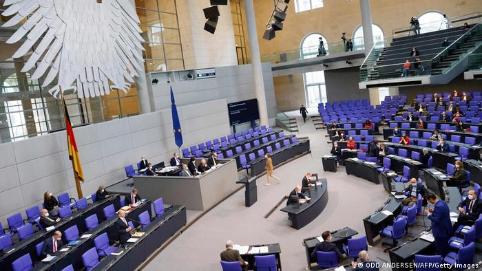 Im Deutschen Bundestag blaue Sitze in einer großen Halle.