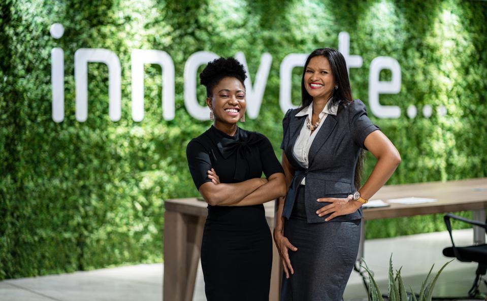 Porträt der schwarzen Geschäftsfrauen, die zusammen in einem umweltfreundlichen Büroraum stehen